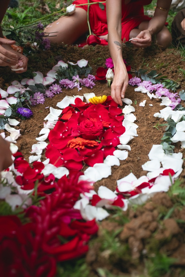 A womb-shaped mandala of red and white flower petals